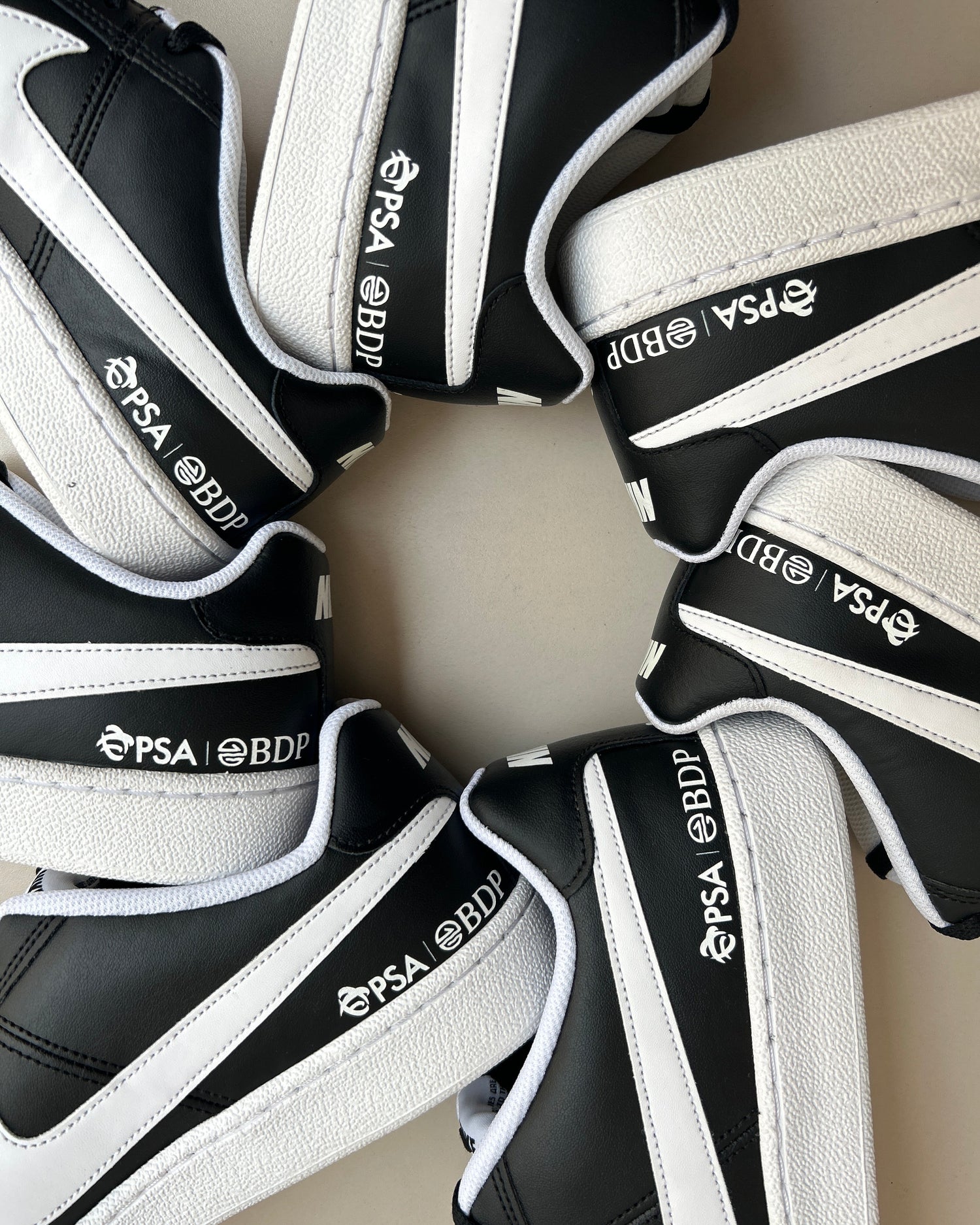 Black and white sports equipment with 'PSA BDP' branding arranged in a circular pattern.