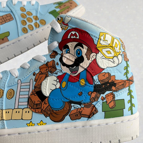 Close-up detail of a custom hand-painted Nike Air Jordan 1 Mid sneaker inspired by Nintendo’s Super Mario, showcasing Mario breaking through bricks with retro game elements painted by hand on sky-blue leather.
