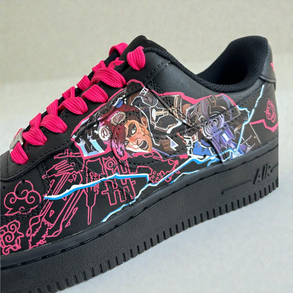 Close-up of custom Nike Air Force 1 sneaker inspired by Jinx from Arcane, featuring hand-painted character artwork, neon pink line art, electric blue detailing, and bright pink laces on a black leather base.