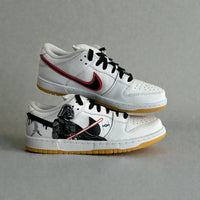 Custom Nike Dunk Low Star Wars sneakers with hand-painted Darth Vader artwork, red lightsaber detail, black swoosh, and gum outsole.