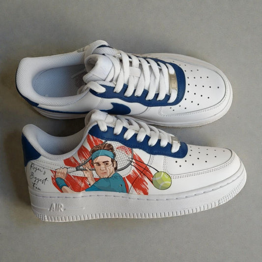 Custom hand-painted Nike Air Force 1 sneakers inspired by tennis legend Roger Federer, featuring an illustrated portrait with racket and tennis ball, painted by hand on a white leather base with blue accents, photographed in a side profile pair shot.