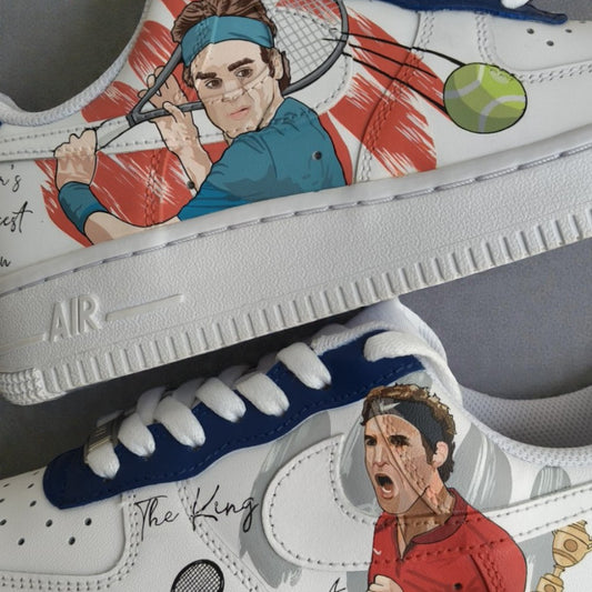 Close-up detail of custom hand-painted Nike Air Force 1 sneakers inspired by tennis legend Roger Federer, showcasing illustrated action portraits, racket and tennis ball elements, and hand-painted artwork on a white leather base with blue accents.