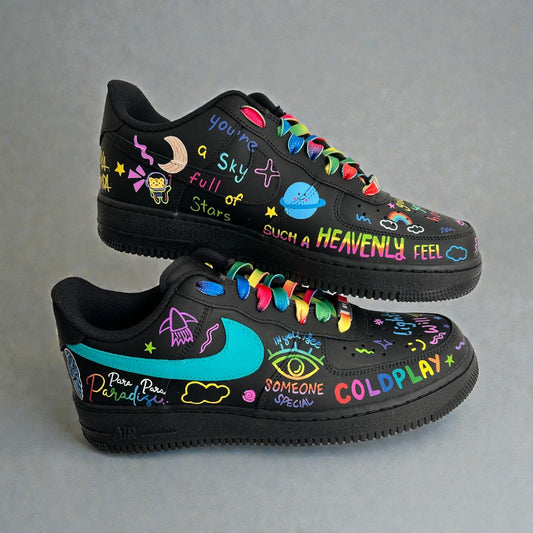 Custom hand-painted black Air Force 1 sneakers inspired by Coldplay, featuring colourful doodle artwork, lyric typography, rainbow laces, and teal swoosh on leather base.