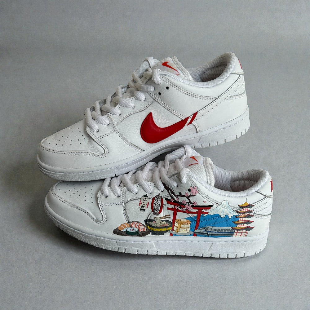 Custom hand-painted white Nike sneakers featuring Japanese cityscape illustrations with torii gate, cherry blossoms, food motifs, and travel-inspired artwork.