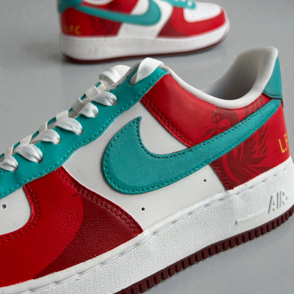 Close-up of custom Nike Air Force 1 sneaker in red, white, and teal, featuring a teal suede swoosh, white leather panels, and hand-finished detailing.