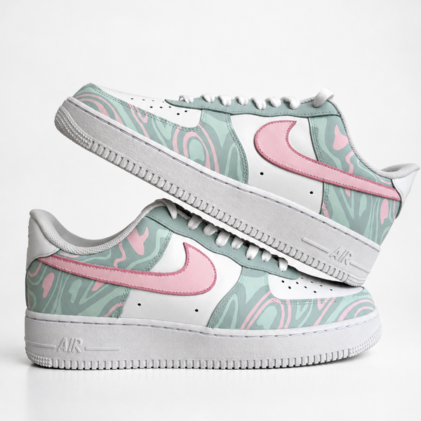 A pair of Nike Air Force 1 Low handpainted custom sneakers featuring a pastel mint green and pink marble pattern on the overlays, white leather panels, and white midsoles with gray detailing.