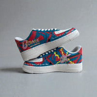 Side view of custom hand-painted Nike Air Force 1 sneakers inspired by David Bowie, featuring bold red and blue graphic artwork, lightning bolt details, guitar illustration, and lyric-inspired text on white leather.