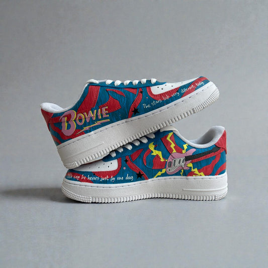 Side view of custom hand-painted Nike Air Force 1 sneakers inspired by David Bowie, featuring bold red and blue graphic artwork, lightning bolt details, guitar illustration, and lyric-inspired text on white leather.