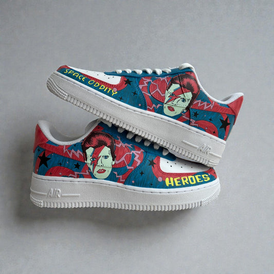 Side view of custom hand-painted Nike Air Force 1 sneakers inspired by David Bowie’s Space Oddity and Heroes era, featuring illustrated Bowie portrait, lightning bolt face paint, bold red and blue graphic background, and lyric text on white leather.