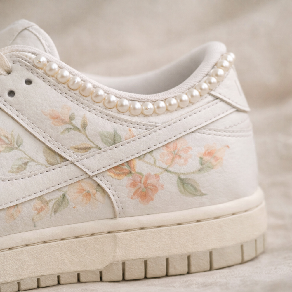 Floral-patterned sneaker with pearl embellishments on a neutral background