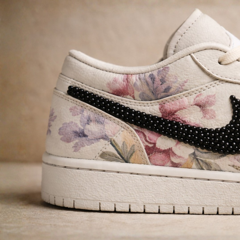 Floral-patterned sneaker with black speckled swoosh logo on a beige background