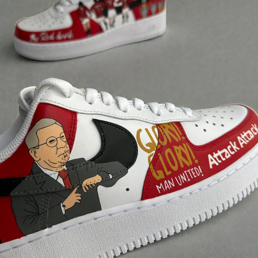 Close-up of custom hand-painted Nike Air Force 1 sneaker inspired by Manchester United, featuring an illustrated portrait of Sir Alex Ferguson, bold red club colours, and hand-painted typography on premium white leather.
