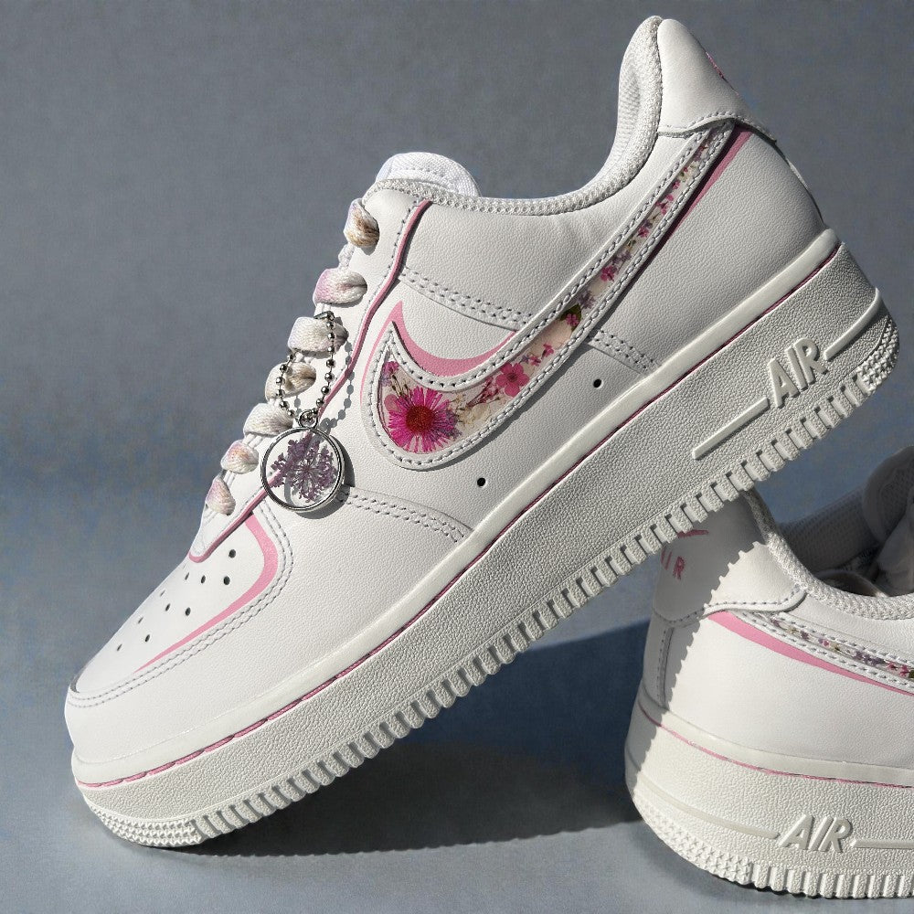 White sneakers with floral design and decorative elements on a gray background