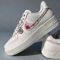 White sneakers with floral design and decorative elements on a gray background