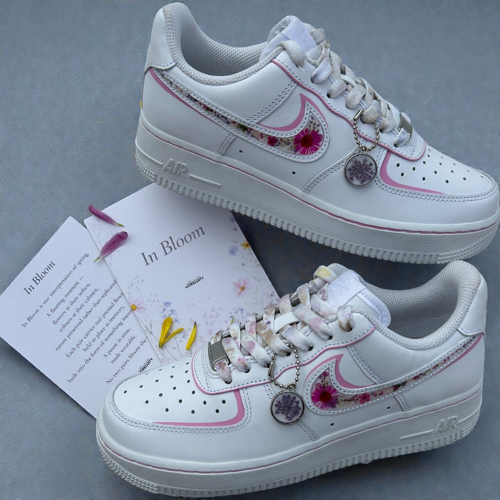 White sneakers with floral and heart designs on a gray background