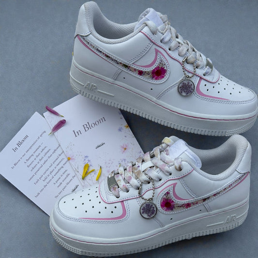 White sneakers with floral and heart designs on a gray background